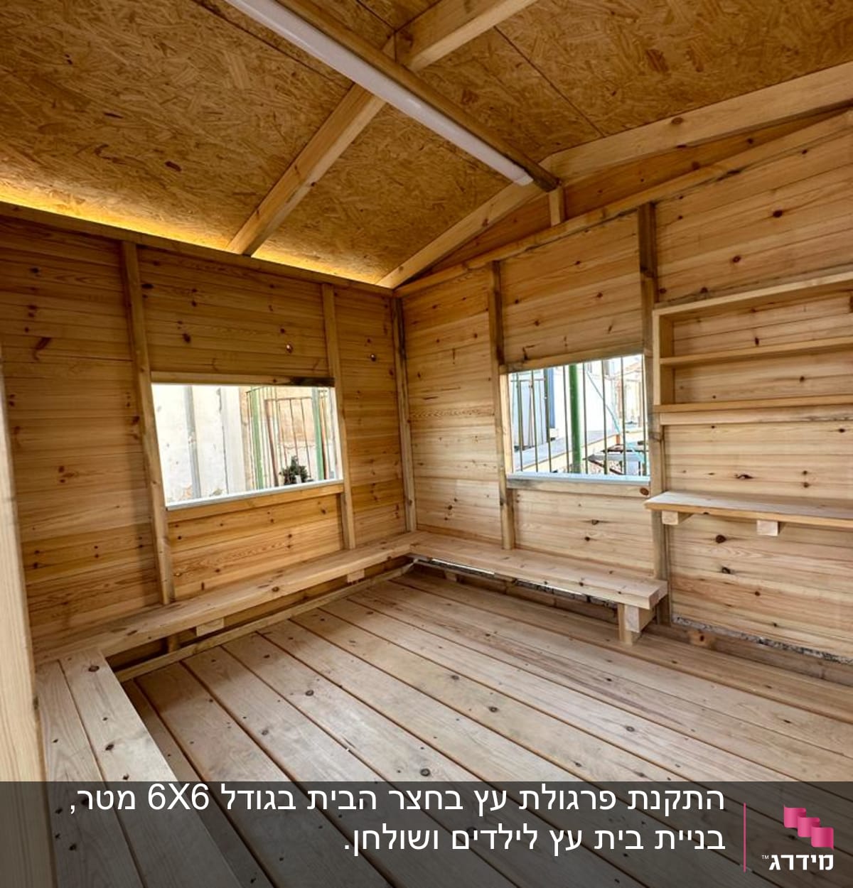 פנים מבנה עץ עם רצפה וקירות מעץ, חלונות ומדפים.